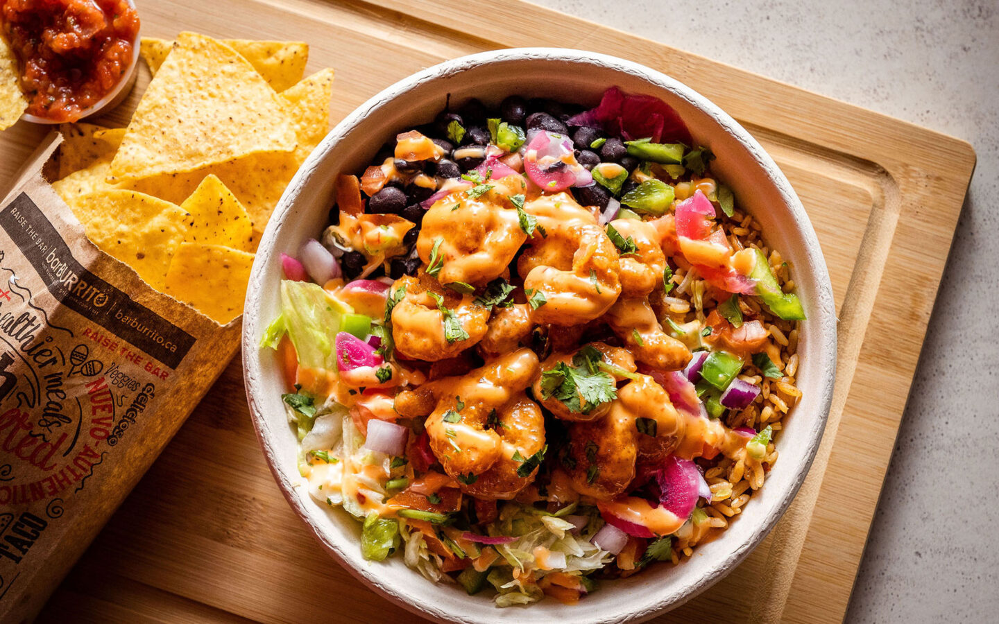 overhead photo of a shrimp burrito bowl on a wooden board