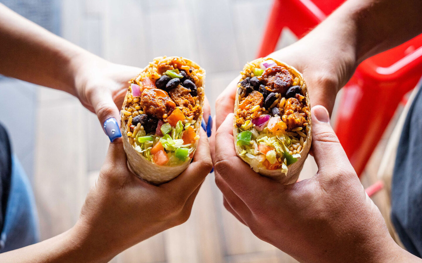 two people holding their burritos side by side