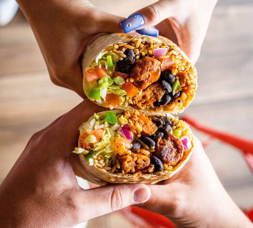 two people holding their burritos side by side