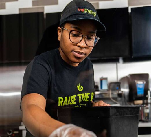 an employee filling up toppings at a restaurant counter